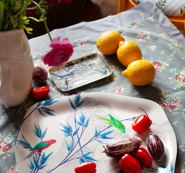 Plateau rococo Le Jardin des Perroquets présenté sur une table avec décoration, artisanat suédois créé à Paris