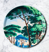 "Plateau décoratif rond motif paysage méditerranéen avec palmiers et architecture, fond turquoise"