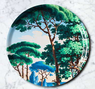 "Plateau décoratif rond motif paysage méditerranéen avec palmiers et architecture, fond turquoise"